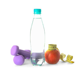 Bottle of water, apple, dumbbells and measuring tape on white background