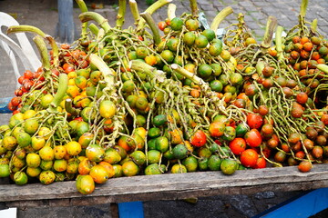 Bunches of colourful pupunha fruits (Bactris gasipaes). Tropical fruit in Brazil. Public City...