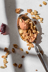 granola in a spoon on a light background