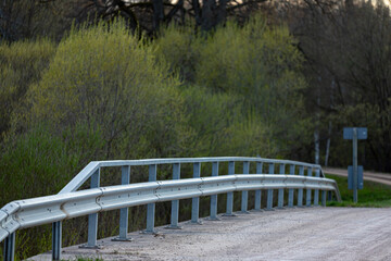 bridge with railing over river Sesava in Latvia which flows through the forest