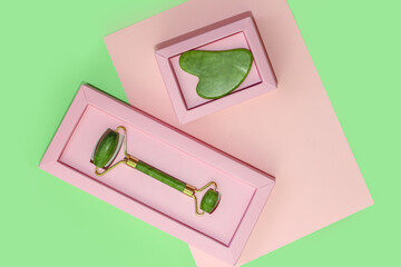 Set of gouache scraper and jade roller on abstract paper background.