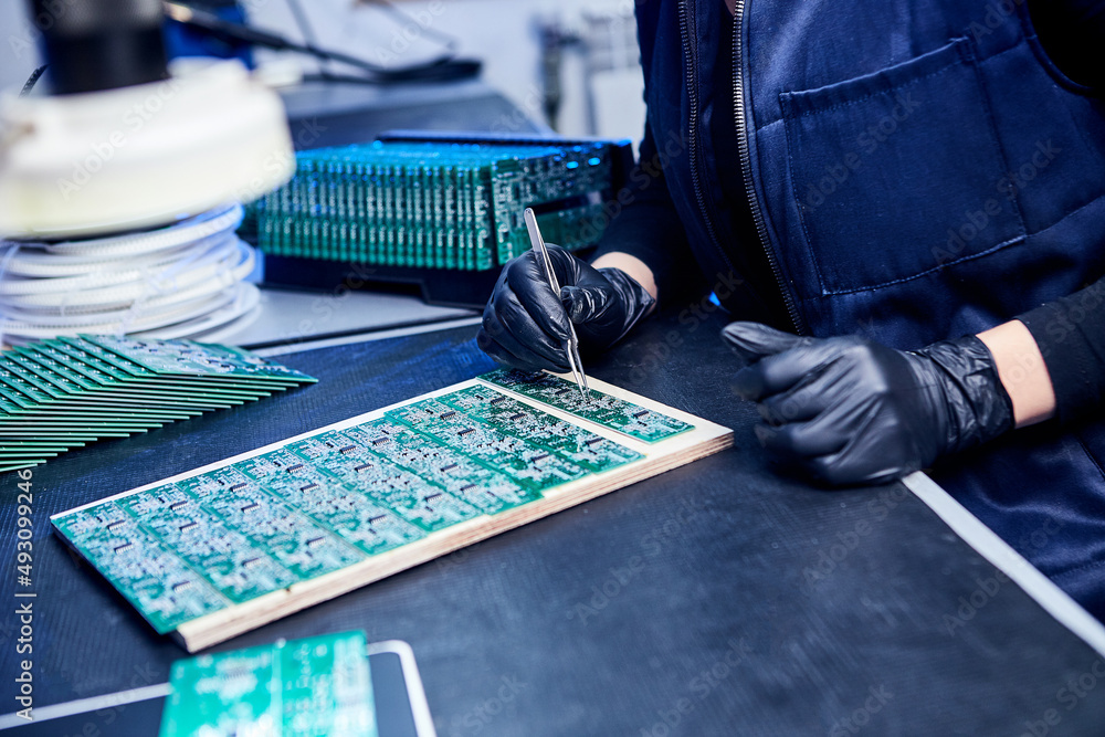 Wall mural Engineer factory worker electronics works with a chip (board). Microchip Production, Nano computer Technology and manufacturing technological process