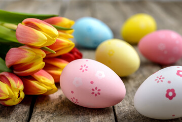 Fototapeta na wymiar Easter eggs and tulips on wooden background