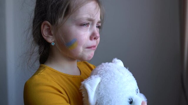 Upset Ukrainian girl kid crying protesting war conflict. Crisis, peace, stop aggression, child against Russian war