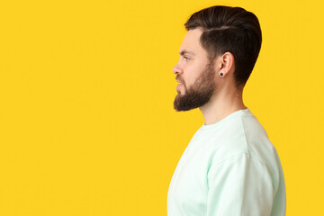Stylish bearded man on yellow background