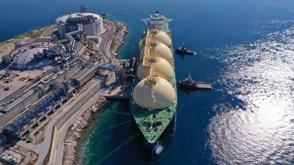 Aerial drone photo of LNG (Liquified Natural Gas) tanker anchored in small LNG industrial islet of Revithoussa equipped with tanks for storage, Salamina, Greece © aerial-drone