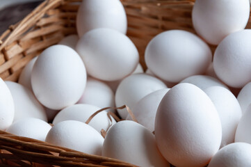 Basket with white eggs. White eggs in a wicker basket. Simple composition. Spring. Day light. Close uup. Easter.