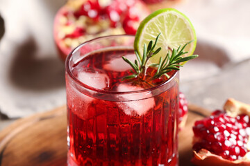 Glass of tasty pomegranate cocktail on table, closeup
