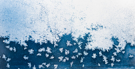 Defocused beautiful frost on window glass with copy space . Blue and white  fern frost pattern. Winter beautiful copy space background