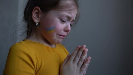 Upset Ukrainian girl kid crying protesting war conflict. Crisis, peace, stop aggression, child against Russian war