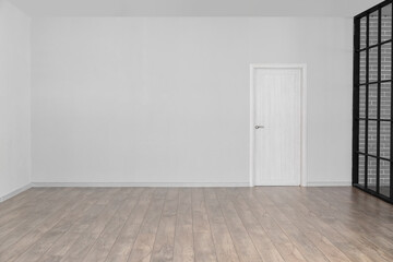 View of big empty room with light wall and door