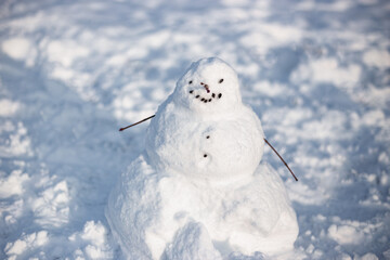 Snow man close up. Funny snow man made by children  on playground in winter.
