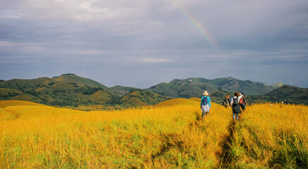 Rear view of hikers against mountains amidst rainbow at Chyulu Hills National Park, Kenya