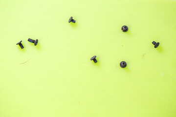 Small screws for twisting small parts for gadgets lie on a green background