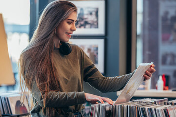 Woman choosing vinyl record in music record shop