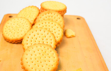 pile of biscuits placed on a wooden cutting board, photo from the top corner, isolated on a white background