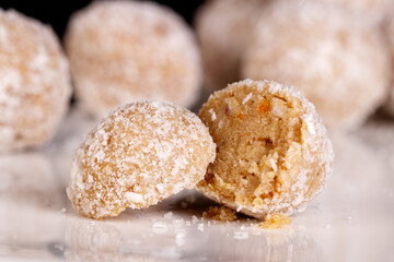 Beautiful sweets with coconut on a white plate on a black background