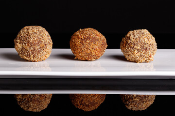 Beautiful candy truffle on a white plate on a black background