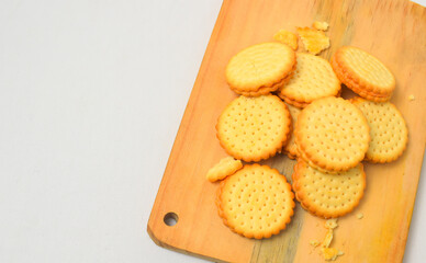 pile of biscuits placed on a wooden cutting board, photo from the top corner, isolated on a white background