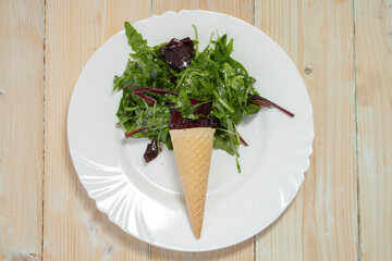 Ice cream cone with an ice cream cone full of green vegetables. Healthy food or weight loss concept