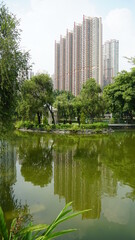 Tin Shui Wai Parque, vista do lago e de um grande edificio residencial, em Hong Kong