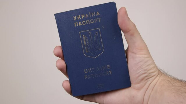 Blue passport of Ukraine male hand holding a document. The concept of tourism, travel, air travel, nationality