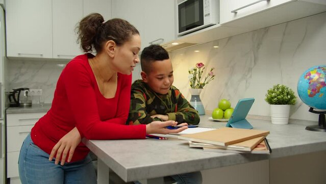 Stressed parent trying to explain educational material to her black son but having learning problems in homeschooling. Cute school boy can't understand schoolwork while e-learning with mother at home.