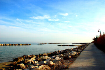 Beautiful promenade near the quiet Adriatic sea surrounded by massive rocks under serene sky with light clouds in Pedaso
