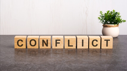 word CONFLICT made with wood building blocks