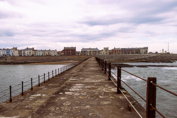 Heugh breakwater pier looking back at houses in small town