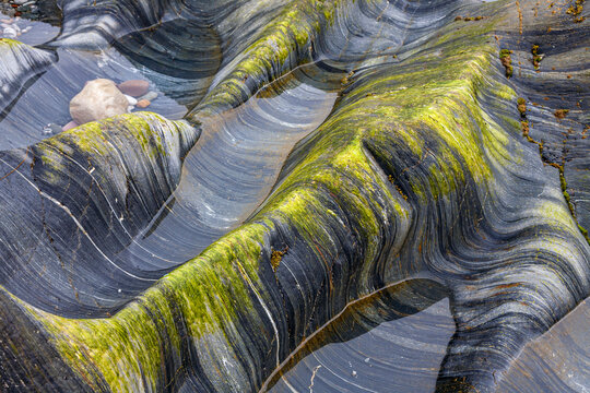 Brandung verursacht Schleifspuren an Felsen