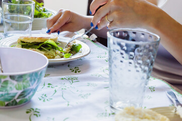 close-up of a woman chopping an arepa with a knife and fork