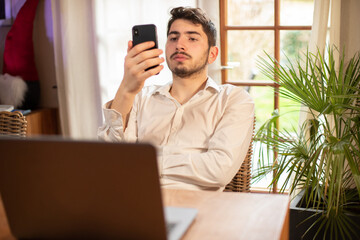 Titre : jeune employé ou homme d'affaire en train de travailler sur son ordinateur portable et qui...
