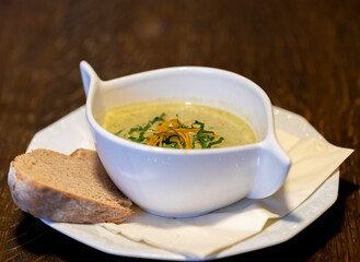 Wild garlic foam soup cream soup in white bowl for restaurant or cafe