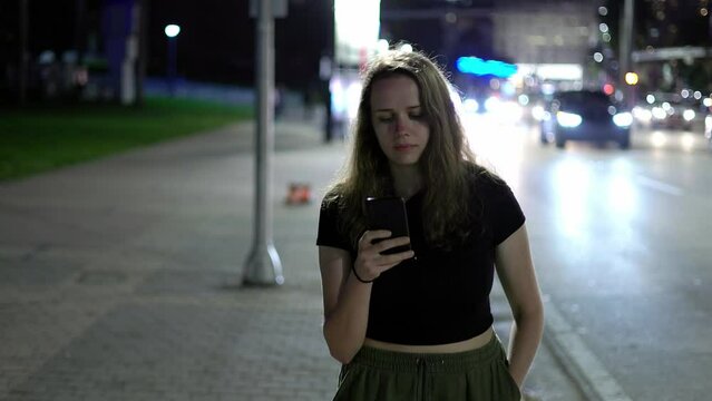 Young woman walking along the street by night - travel photography