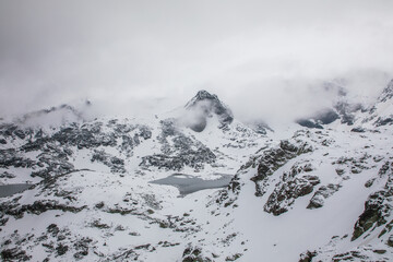 Fototapeta na wymiar White Snowy Mountains Covered in Fog