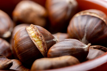 Macro close up of roast chestnuts in a brown bowl