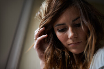 Looking thoughtful at home. An attractive young woman indoors.