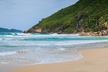 Sandy beach and blue ocean waves. Praia do Rio das Pacas in Brazil