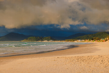 Morro das Pedras beach and ocean with waves. Brazilian beach with sunrise light