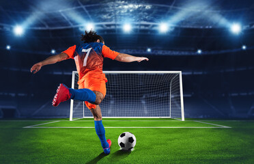 Soccer scene at night match with player in an orange and blue uniform kicking the penalty kick - obrazy, fototapety, plakaty