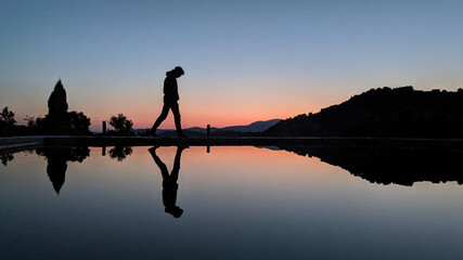Silhouette of a person on the lake during the sunset