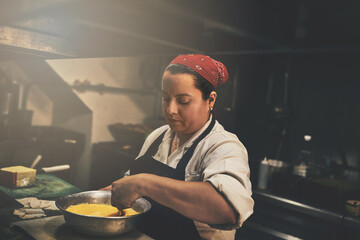 Theres some stirring going on in the kitchen. Shot of a focused chef preparing a dish in the...