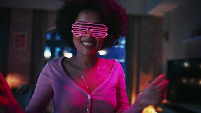 Portrait of Multiethnic Young Latin Female Dancing in Futuristic Neon Glowing Glasses, Having a Party at Home in Loft Apartment. Recording Funny Viral Videos for Social Media. Close Up Zoom Shot.