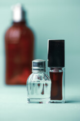 Glass bottles of eau de toilette, perfumes, fragrances on blue background. Cosmetic essential aroma...