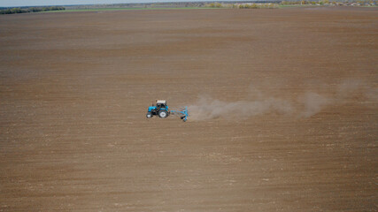 Farming: a farmer on a tractor works the field before sowing