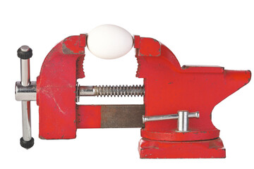 An Egg in the Jaws of a Red Metal Bench Vice Isolated on a White Background