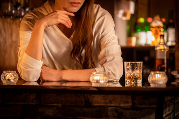 バーカウンターで頬杖をつく女性　BAR	