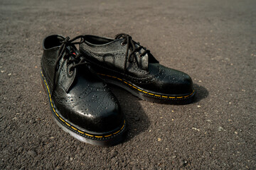 Naklejka premium Detail view of the classic brogue wingtip men's black genuine leather shoes with rubber sole