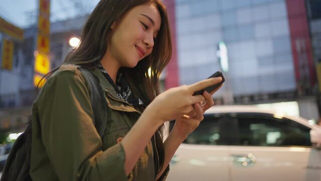 Asian attractive woman backpacker chatting on phone while walk in city